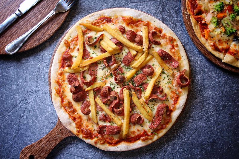 BBQ chicken round table pizza topped with smoky sauce and fresh herbs